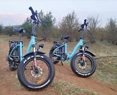 electric bicycle two wheel blue on rough farm terrain
